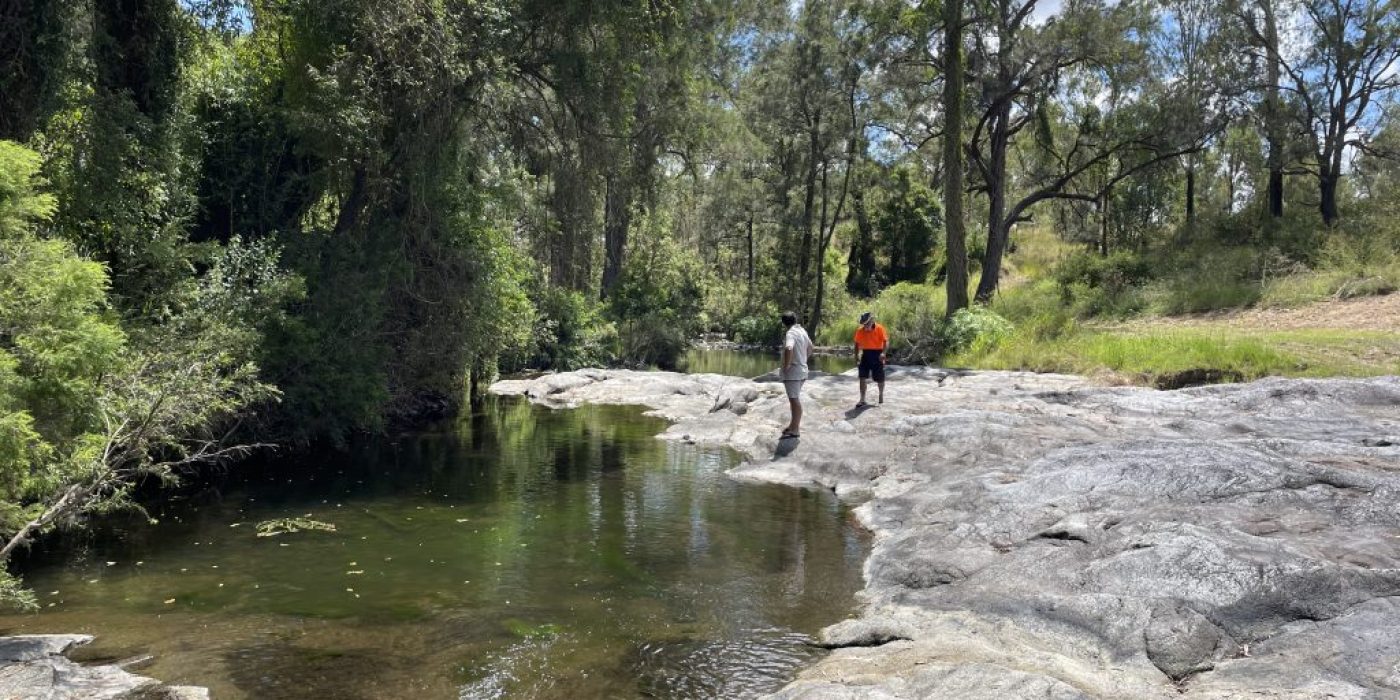 two people on rocks by the creek