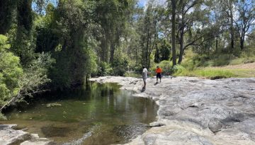 two people on rocks by the creek